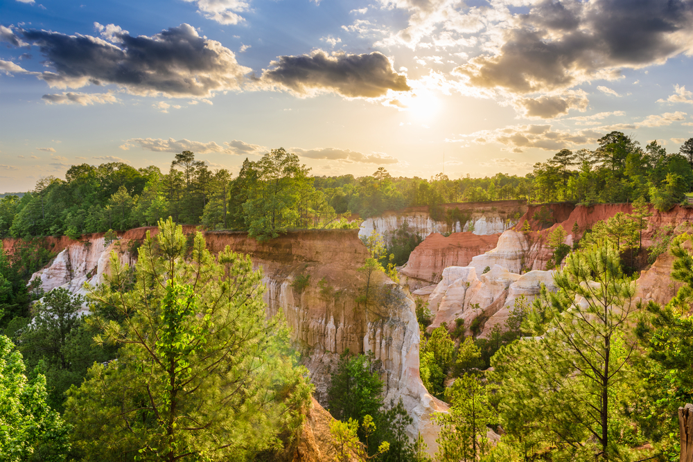 sunrise over gorge with red rocks and green trees in georgia