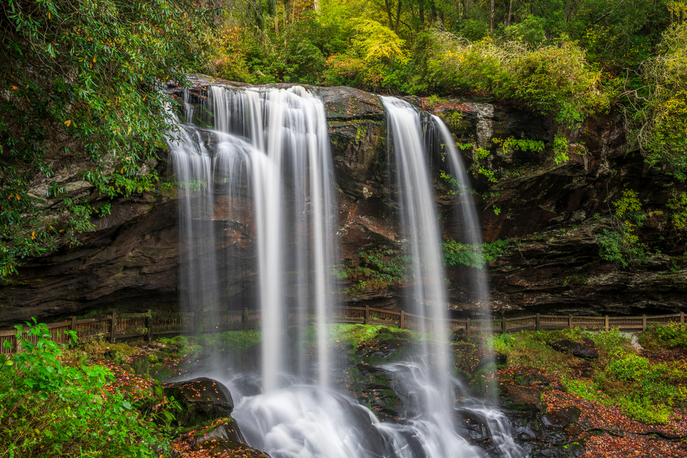 Dry Falls cascading over a rocky ledge with a path behind it.