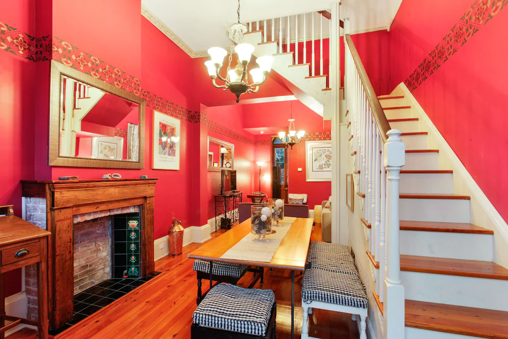 The red walls and exposed brick of the Authentic Creole Cottage make it a perfect place to stay in New Orleans.