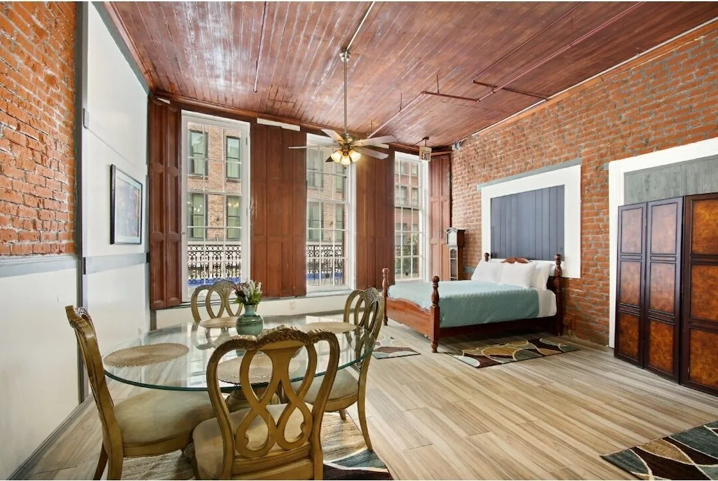 Hardwood floors, exposed brick, and french windows welcome you into the Balcony Suite, one of the best airbnbs in New Orleans.