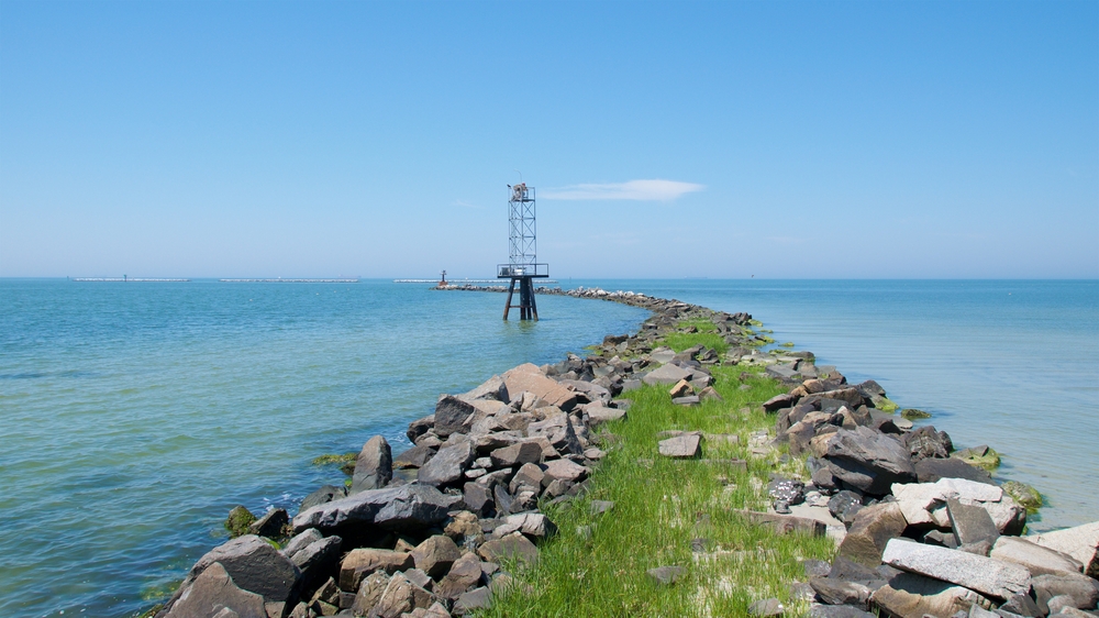 rock jetty out into the blue water on a sunny day