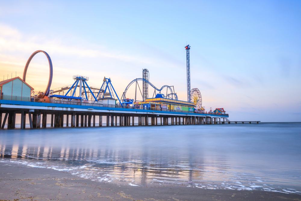 Galveston pier over the water with roller coasters and ferris wheel on it