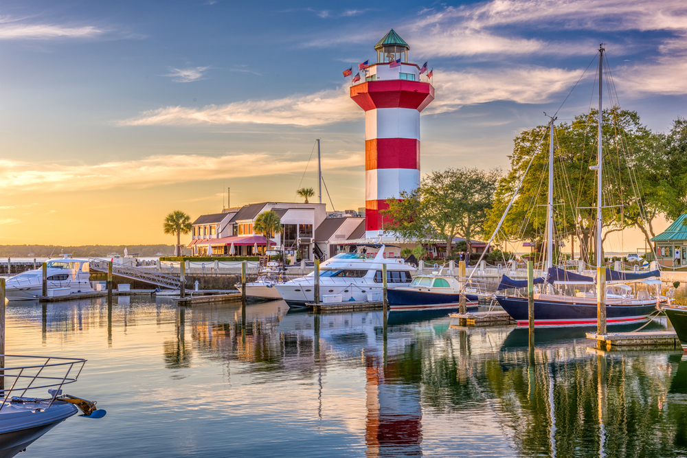 marina, boats on the water, and a red and white striped lighthouse