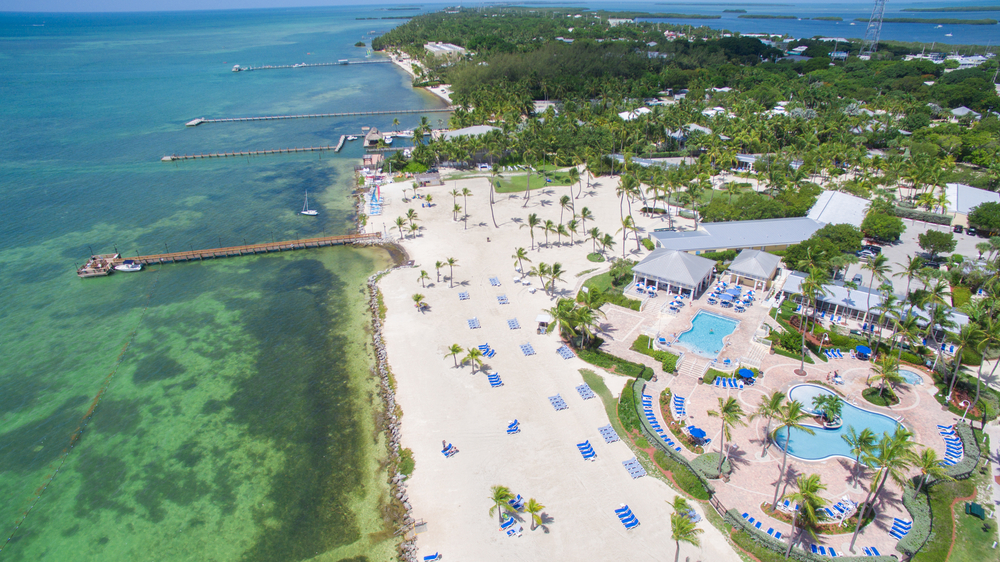 aerial photo of white sand, water, and resorts with swimming pool