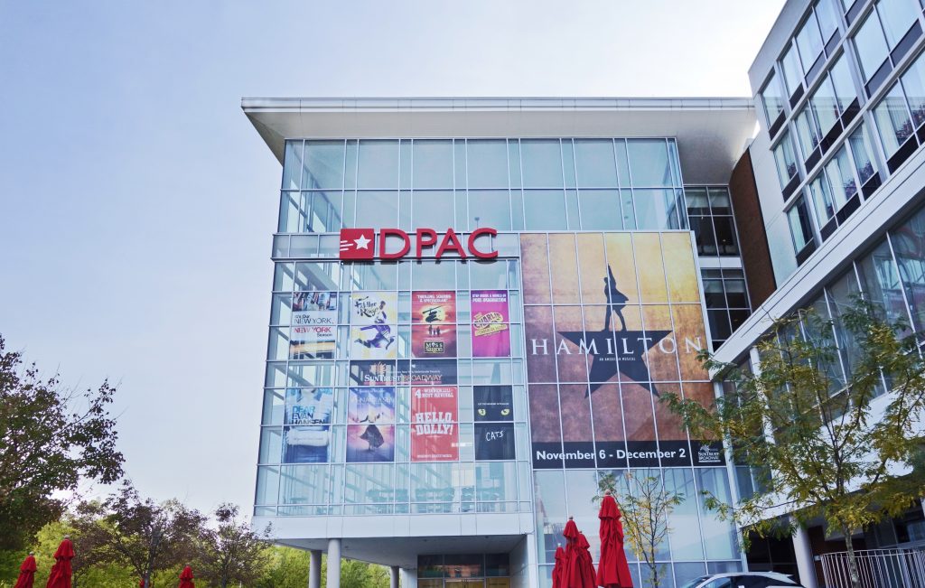 The exterior of the Durham Performing Arts Center, one of the best things to do in North Carolina, displays posters of Broadway shows coming to town.