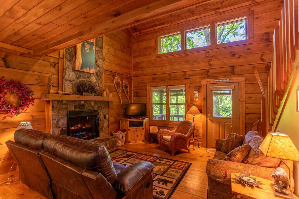 The gorgeous interior of the Bears Repeatin' listing, a beautiful cabin furnished with warm accents with a gigantic fireplace.