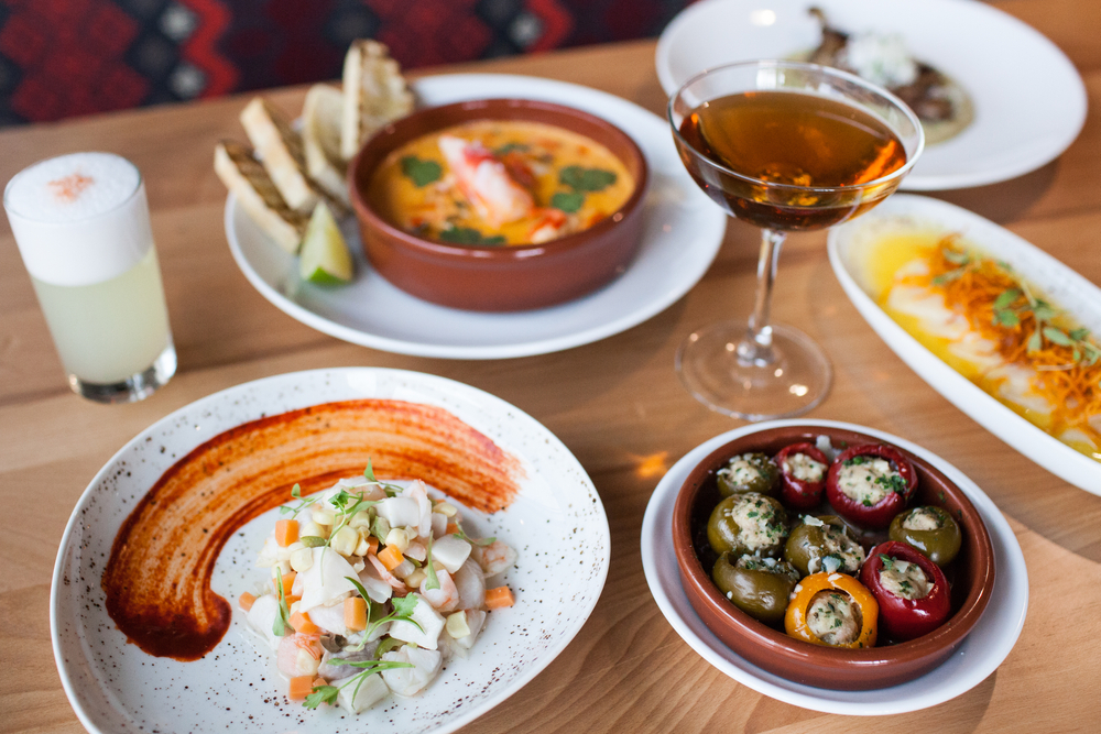 a spanish style tapas dinner with olives, ceviche, wine and more