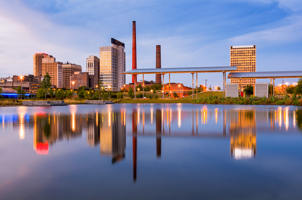 water in front of buildings and smoke stacks in Birmingham, Alabama 