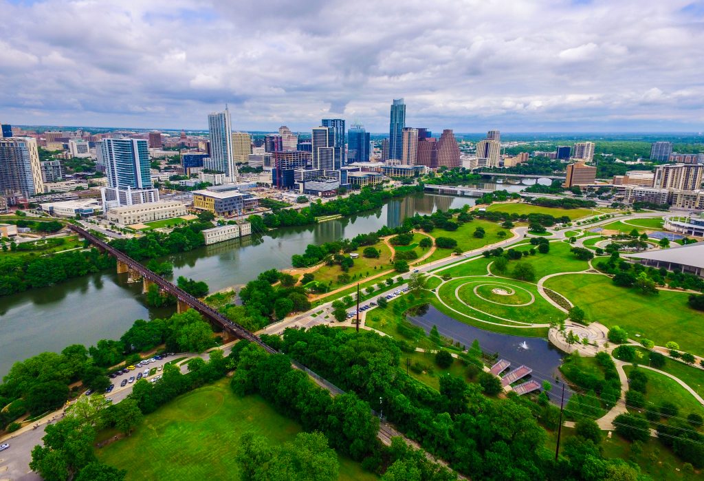 An aerial shot of downtown Austin, showcasing its bridges, gardens, and waterways.