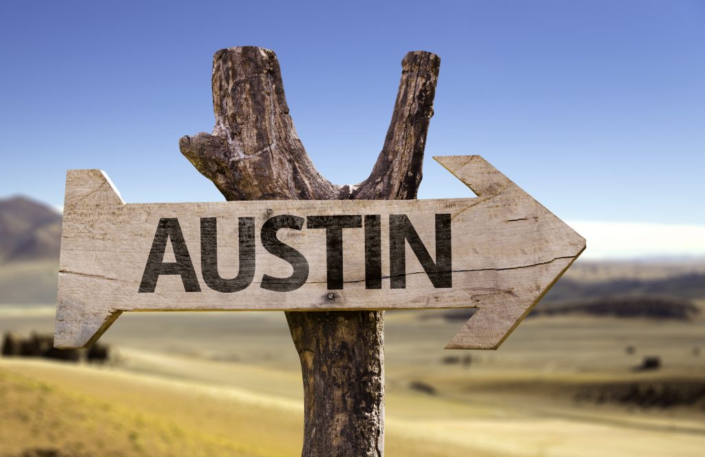 A sign on the side of the road indicates the way to Austin