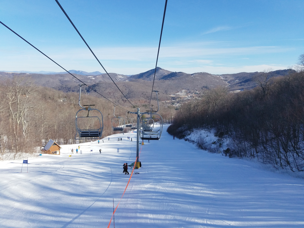 A picture of a ski lift above a snowy slope at Sugar Mountain Ski Resort.