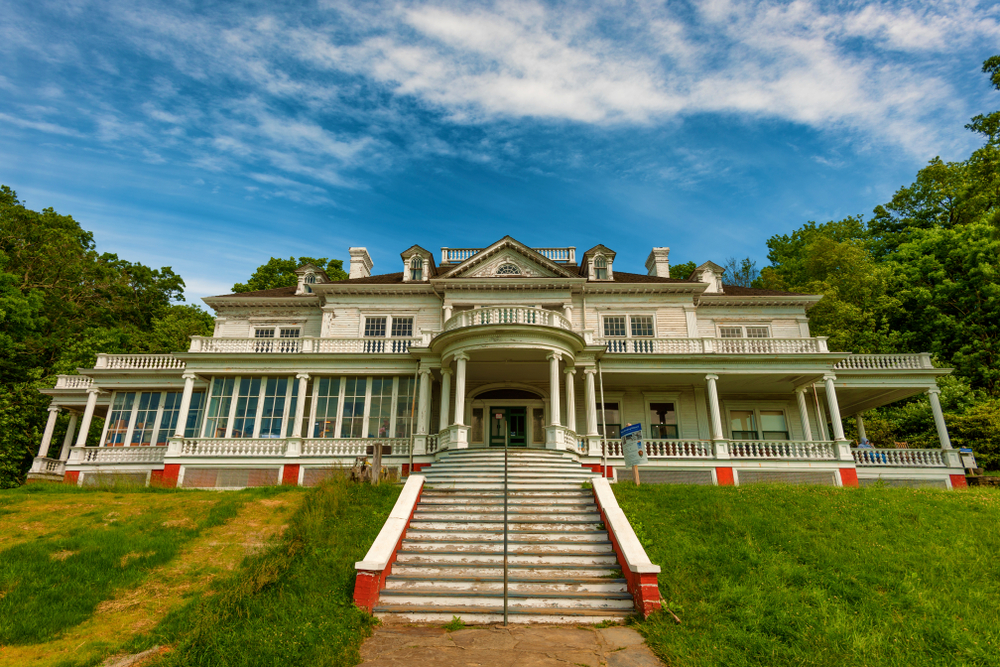 A picture of the large Flat Top Manor, a large historic white home, on a sunny day.