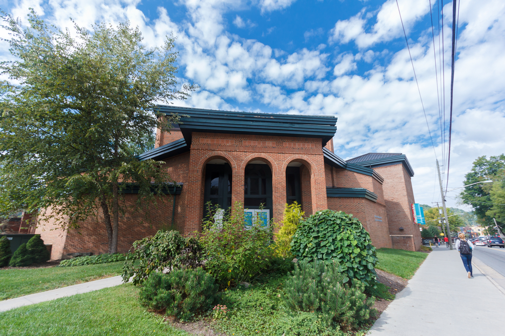 A picture of Turchin Center for the Visual Arts from the outside entrance, showing the 4 arches and the small shrubbery in front of the building. 