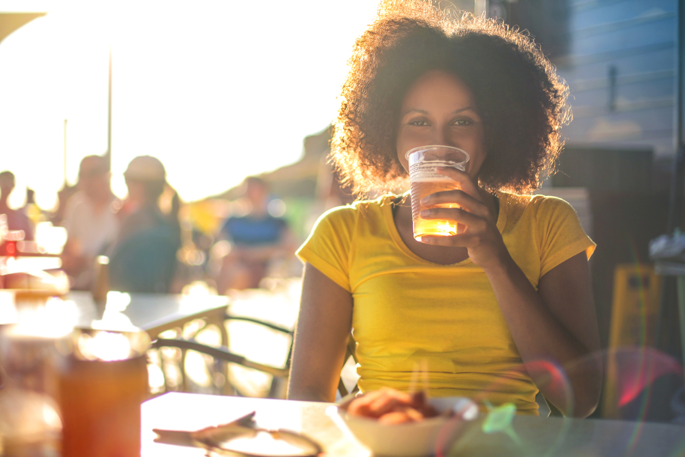 A women drinking a pint of beer on a patio