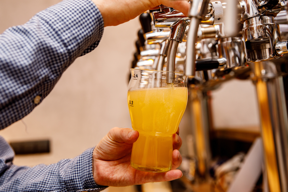 Bartender pouring a pink of beer in an article about breweries in Asheville