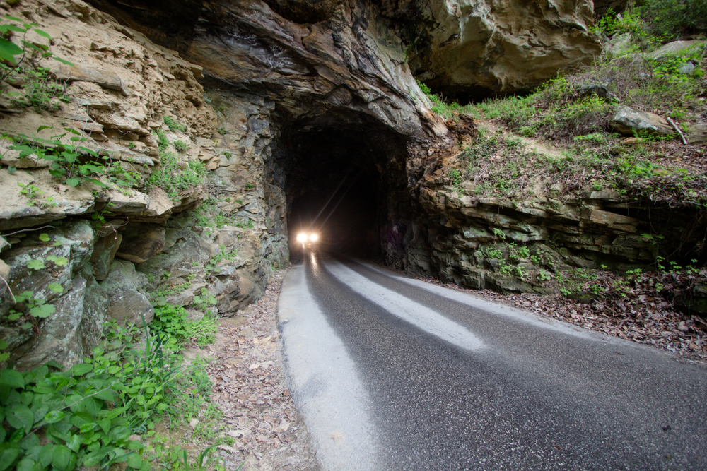 spooky car headlights driving through cave at one of the most haunted places in kentucky