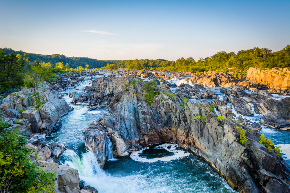 View of waterfalls and river at great falls park decided by large rock formations