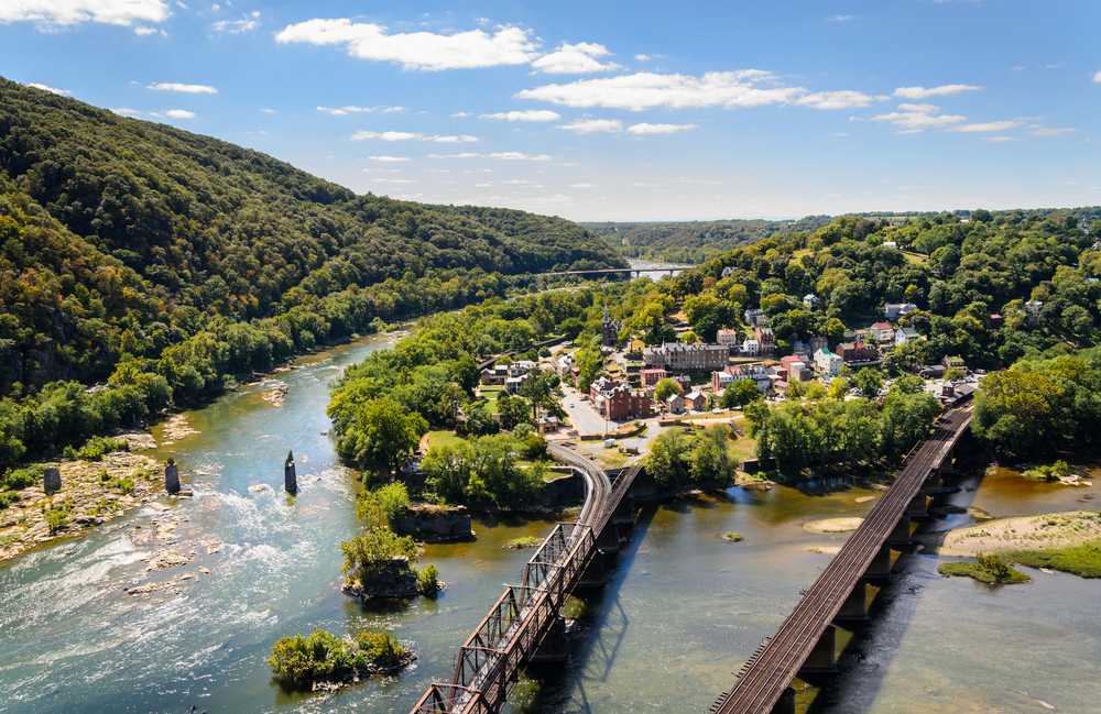 View overlooking the town and river and bridges at harpers ferry with a tree covered hill beside the river