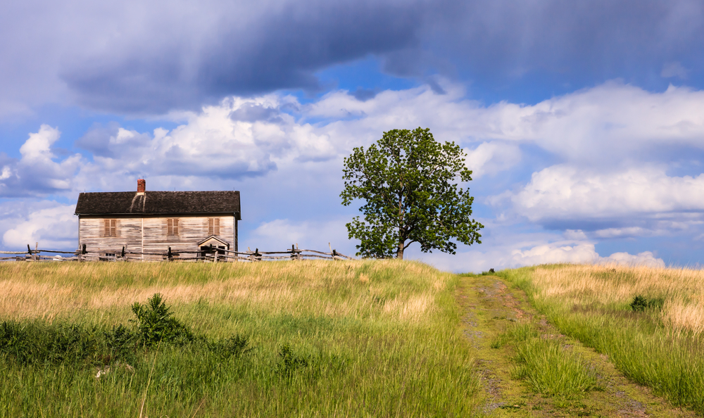 A road running beside Henry House at Manassas national battlefield under a cloudy sky.