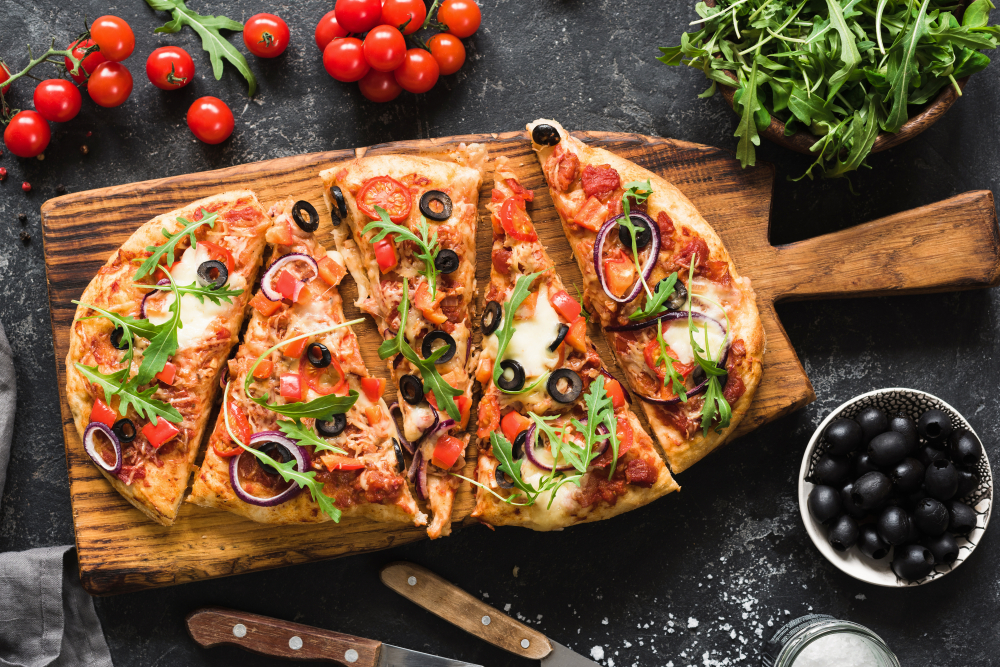 photo of pizza cut diagonally on a cutting board 