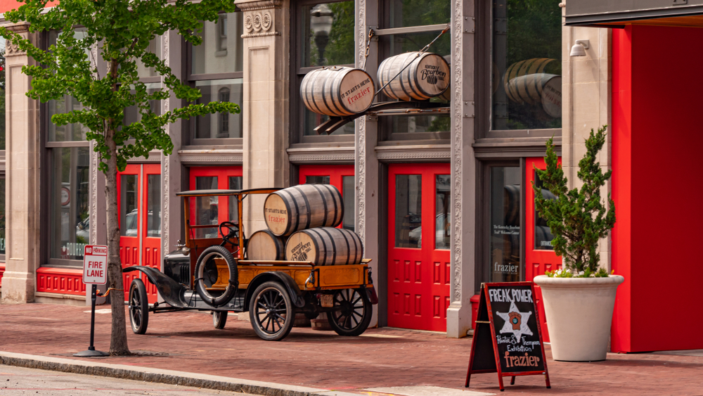 storefront with red doors and wooden barrels out front