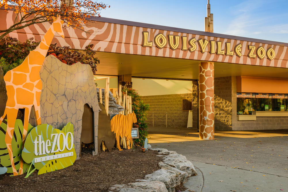 front of the louisville zoo with sign saying louisville zoo