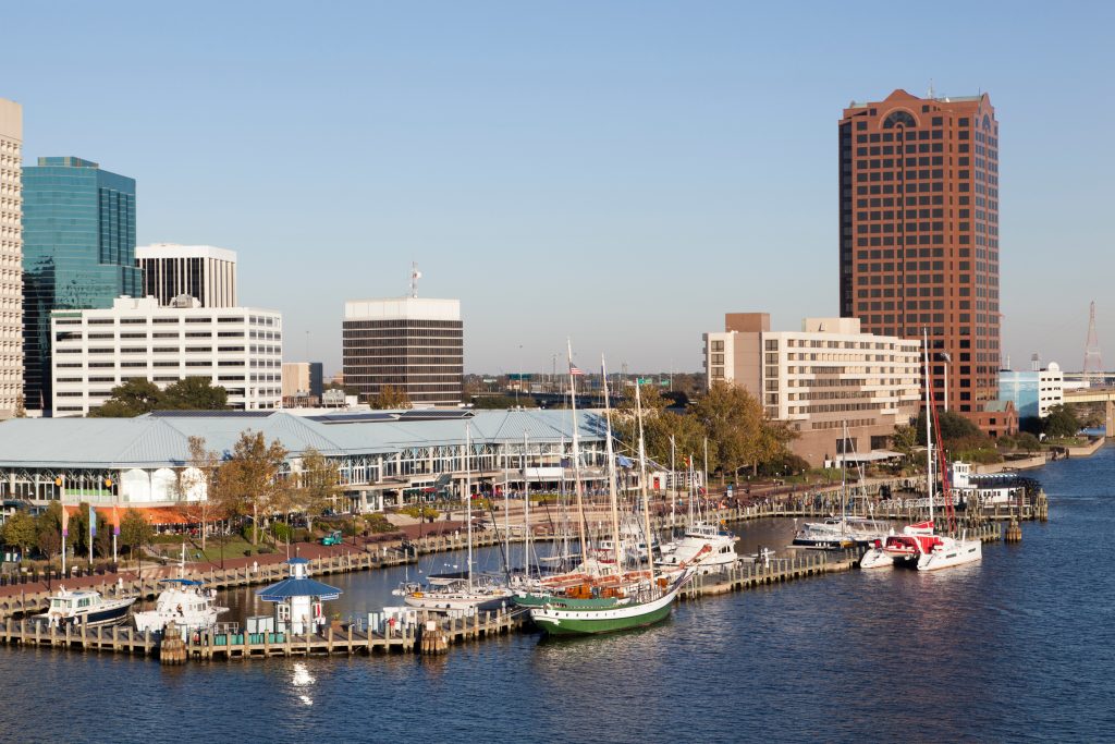 The boats line a dock in downtown Norfolk