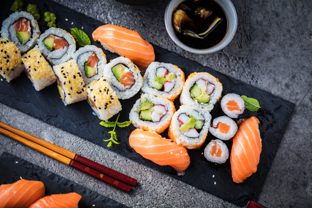 Ariel view of a plate of assorted sushi and chopsticks.