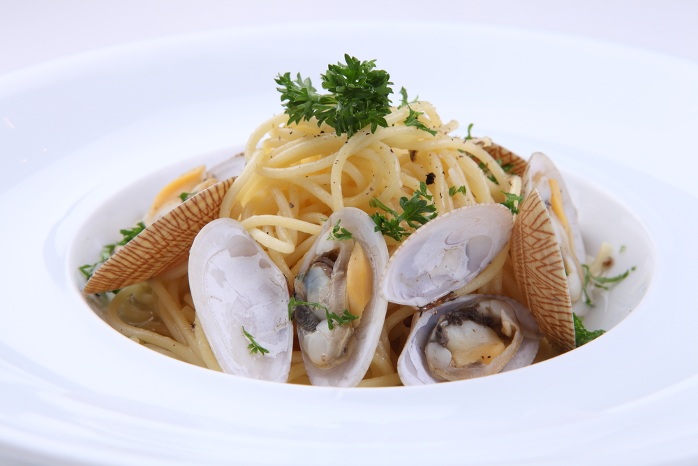 Spaghetti with clams: "Gourmet spaghetti with clams garnished with parsley, served in a white bowl - a fine example of seafood offerings at Birmingham restaurants