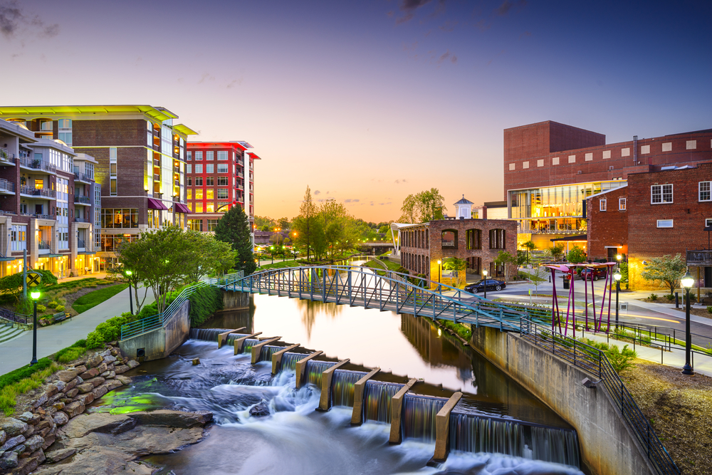 bridge over waterfall in downtown greenville at sunset