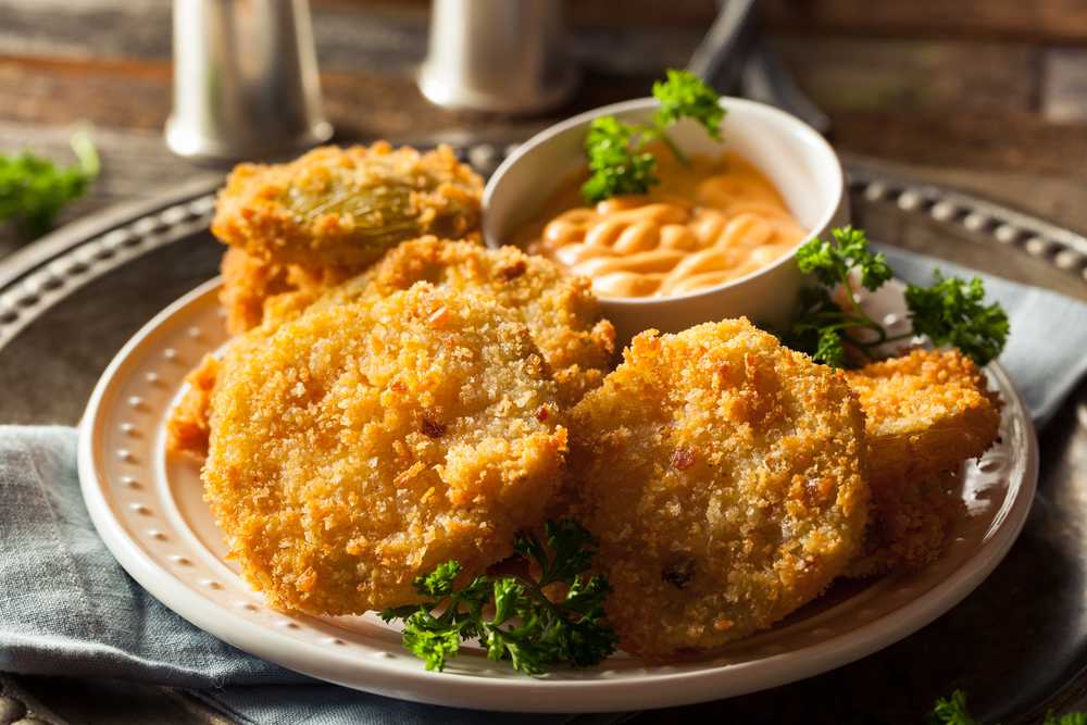 fried green tomatoes with a dipping sauce on white plate