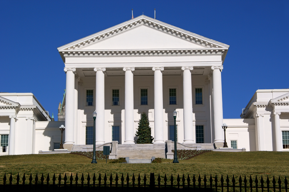 The front of a large government building in Richmond, a great Christmas in the south destination. On the porch of the government building there is a large evergreen tree right in the middle. 