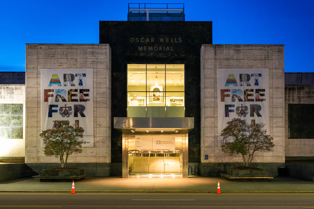 The Oscar Wells Memorial at the Birmingham Museum of Art lit up at night with a dark blue sky, best things to do in Birmingham AL.