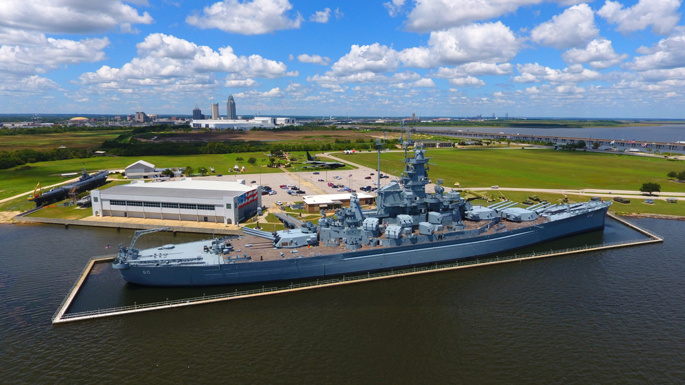 The battleship USS alabama with the city and the mobile bay in the background