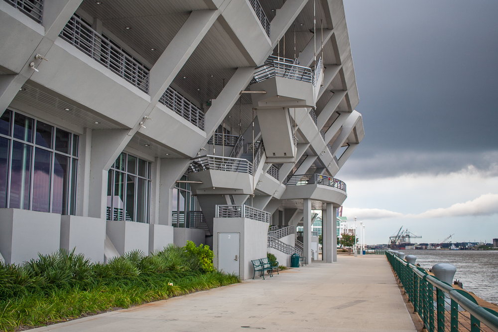 The Geometric grey building of the museum is located on Mobile Bay you can see port in the background