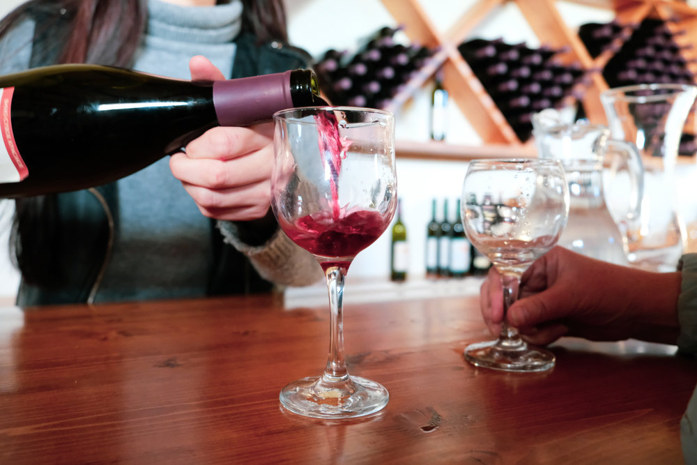 red wine being poured on a bar