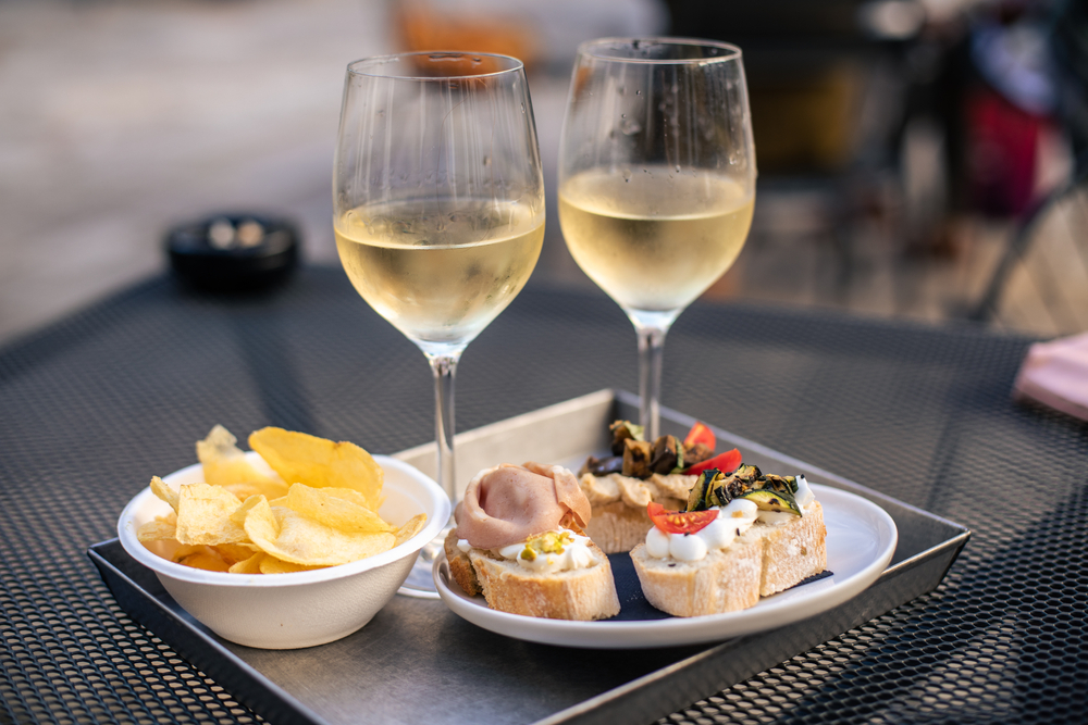 two white wine glasses with food on table