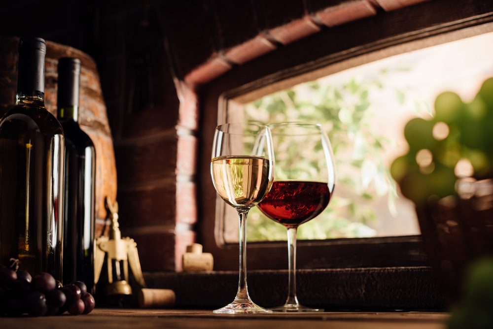 a glass of red wine and a glass of white wine on a wooden table