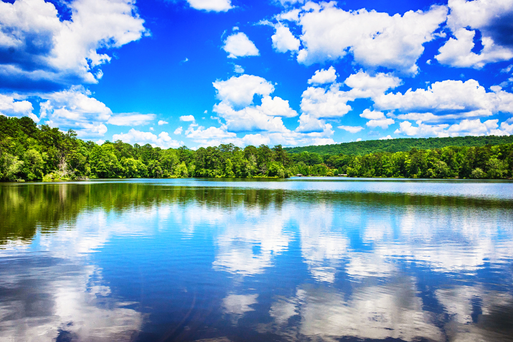 Clouds reflected in the surface of a lake, surrounded by trees, at Callaway Gardens in Georgia.