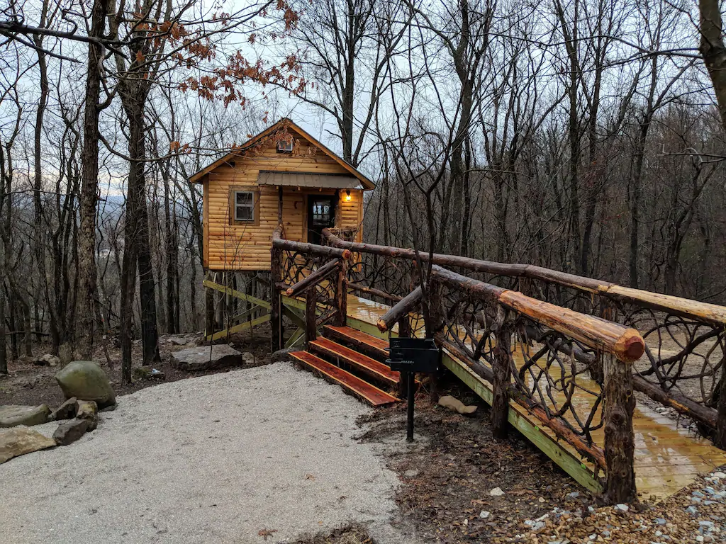 treehouse cabin in arkansas with wooden walkway up to the cabin