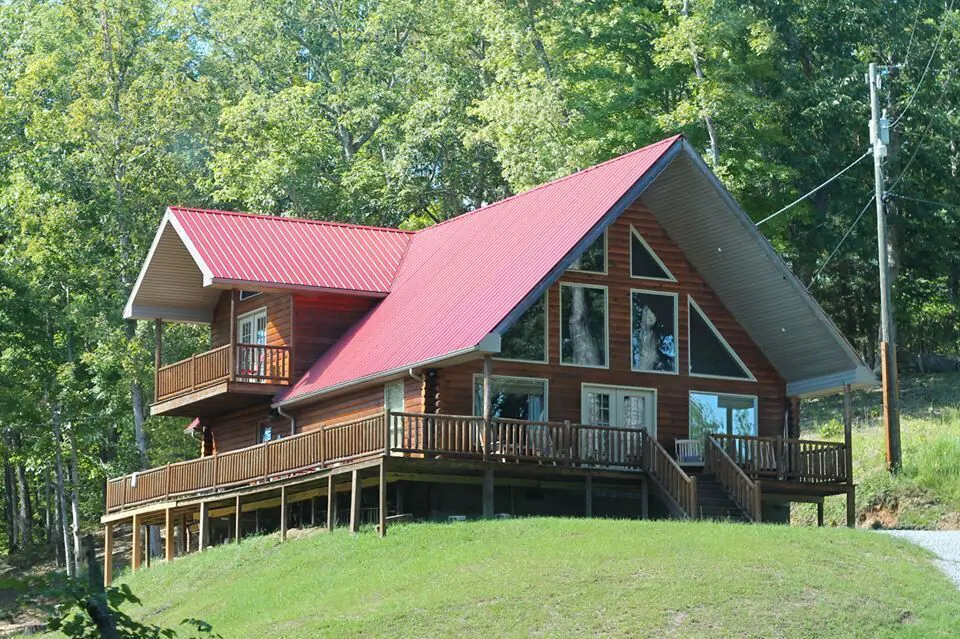 large cabin on hill with tin roof and large porch