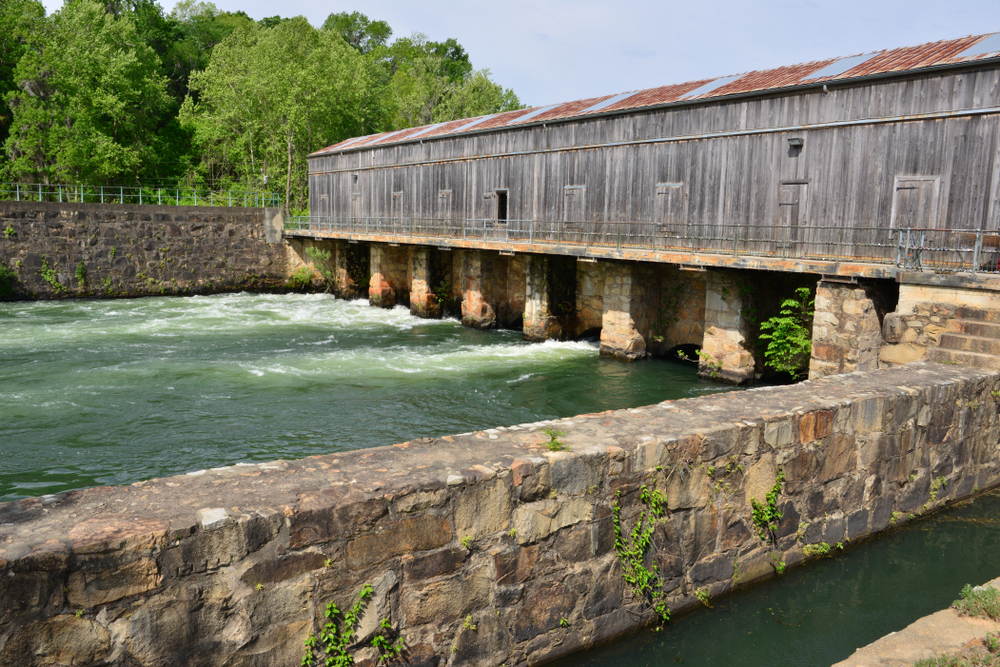 View of water, covered bridge and stone wall at the Augusta Canal Discovery Center.