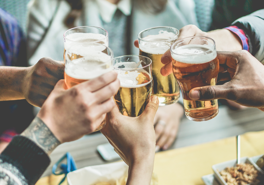 Friends clinking glasses of beer at Blowing Rock Brewery.