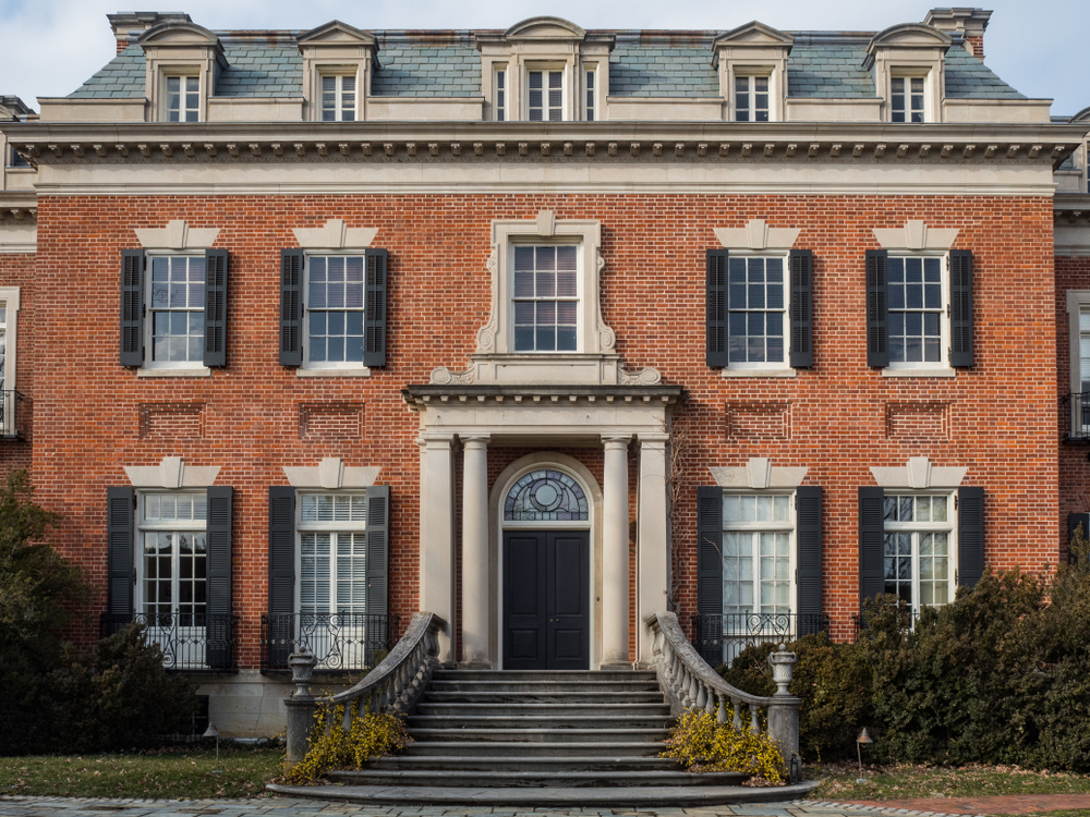 The front of regal, brick Dumbarton Oaks with many windows and columns in Georgetown.