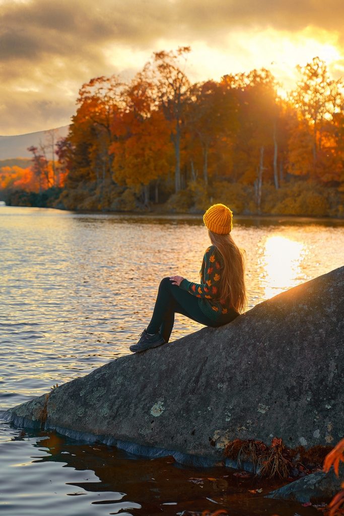 Girl looking out at the lake at sunset at Julian Price Memorial Park, one of the best Blowing Rock attractions.