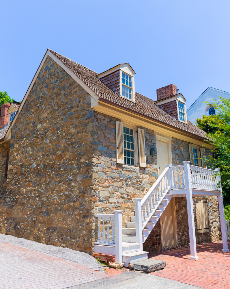 The Old Stone House viewed from outside with white stairs going up to the second story.