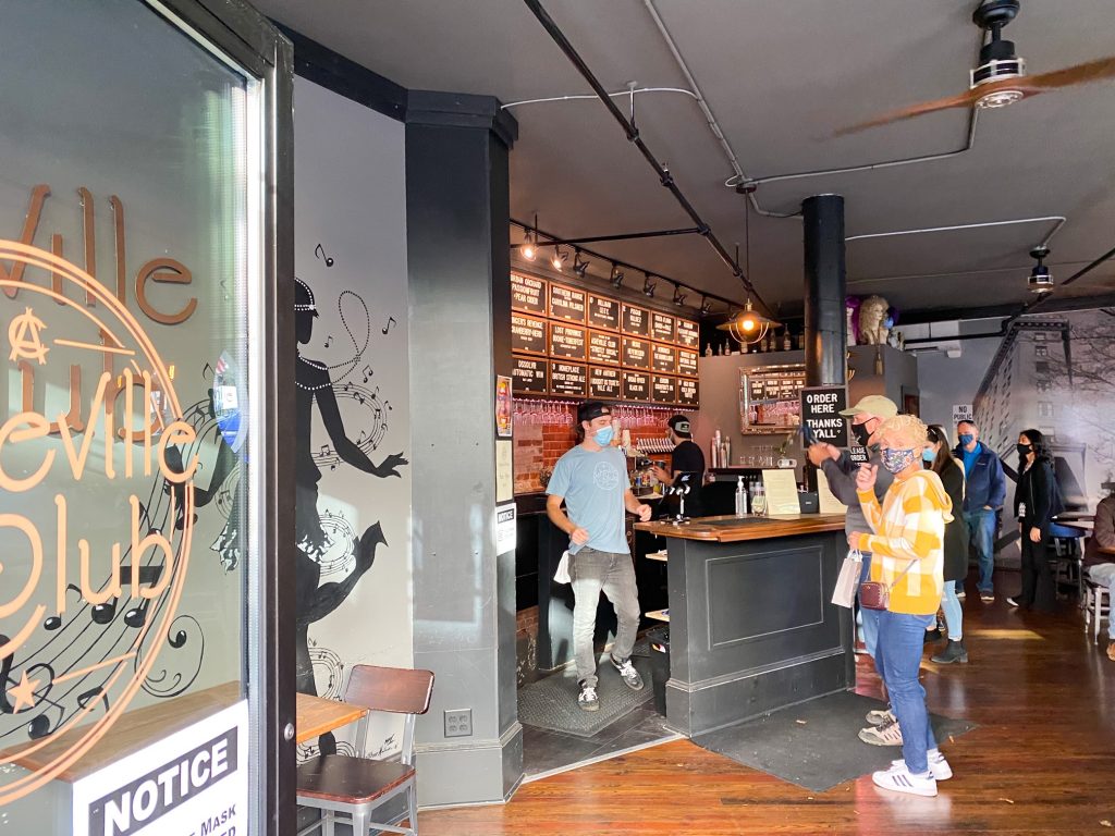 the inside of Asheville Club with people at the coffee bar