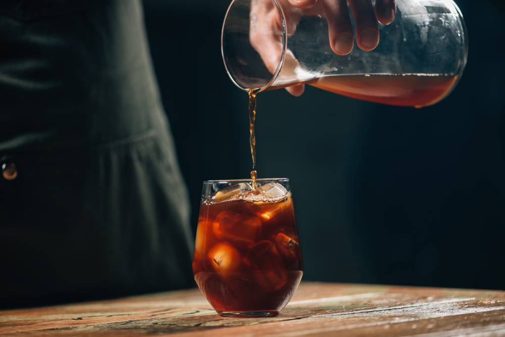 A Barista poring cold brew in an article about coffee in Asheville