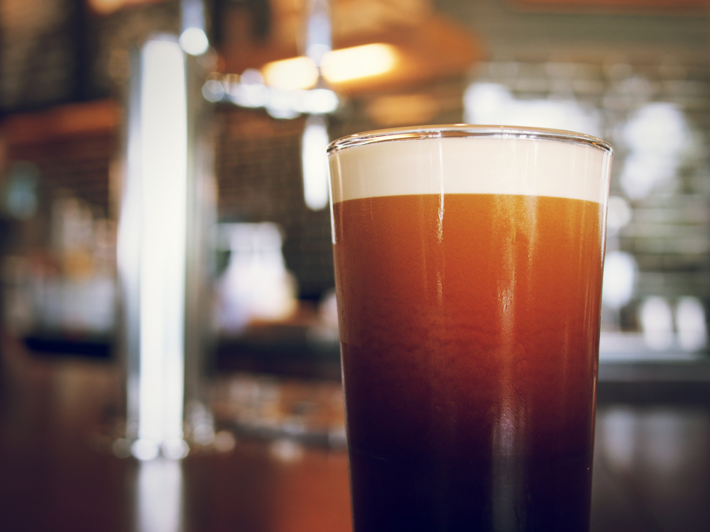 A Nitro Cold Brew on a glass on the coffee bar in an article about coffee in Asheville