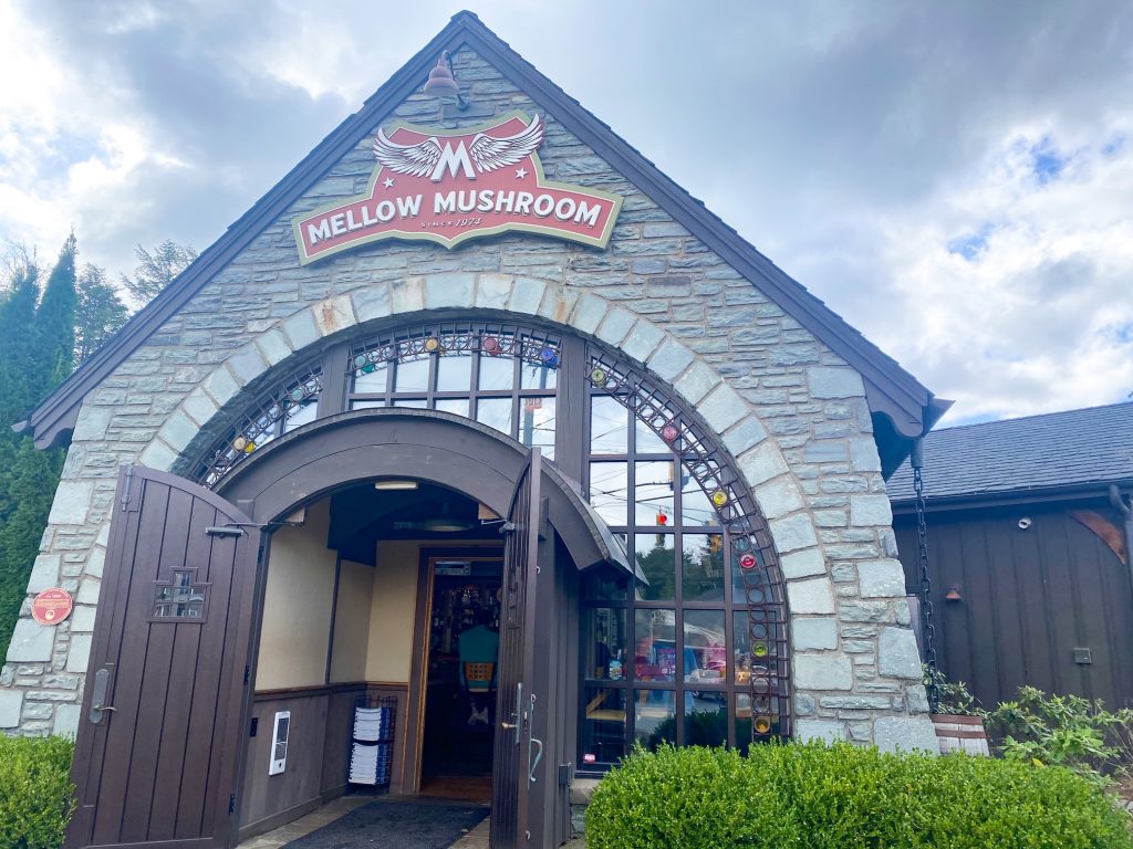 The stone exterior of mellow mushroom with large doors opening you into this pizza restaurant in Blowing Rock